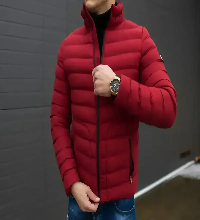 man zipping up a red puffer jacket. crafted by a British coat manufacturer. showcasing modern outwear design